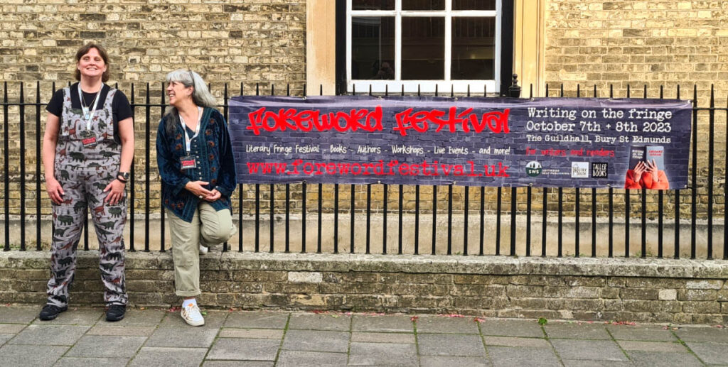 Foreword Festival founders Rachel Churcher and Jackie Carreira with the 2023 festival banner, outside the Guildhall in Bury St Edmunds.